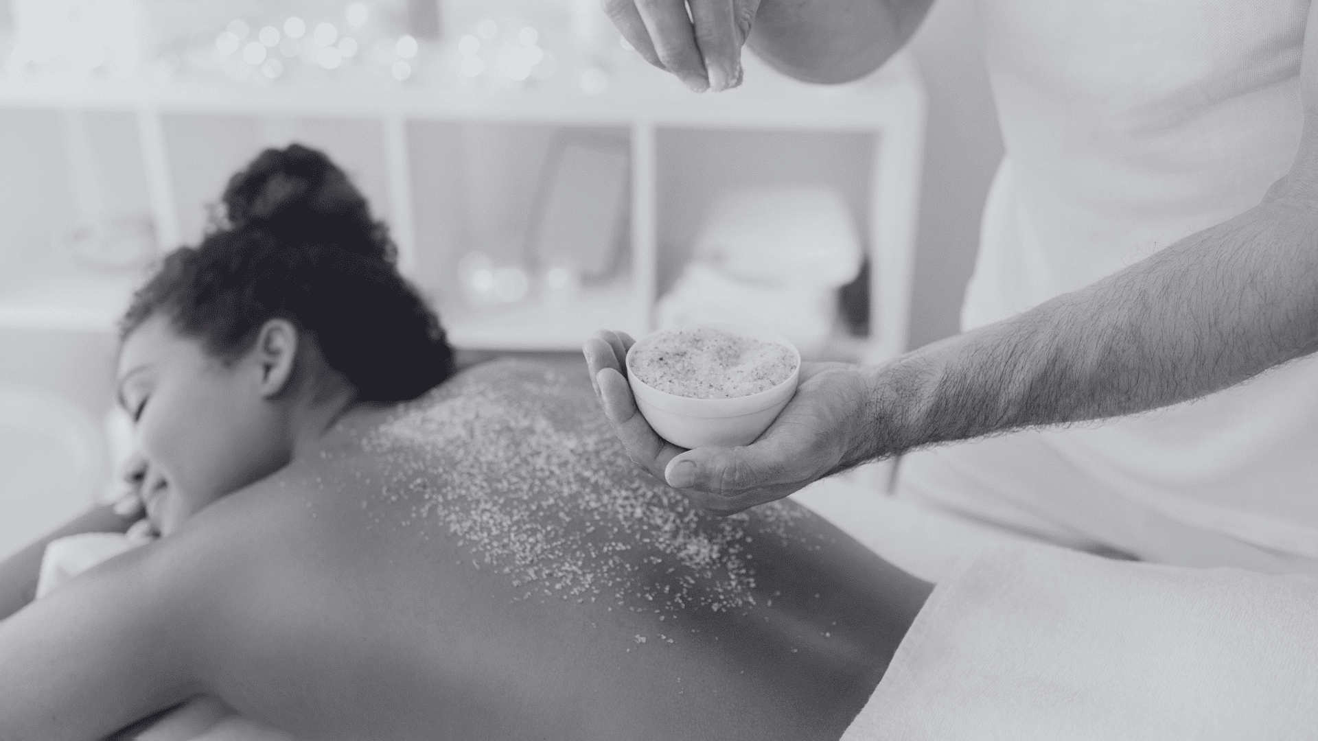 A person receiving a relaxing back massage with exfoliating scrub in a spa setting.