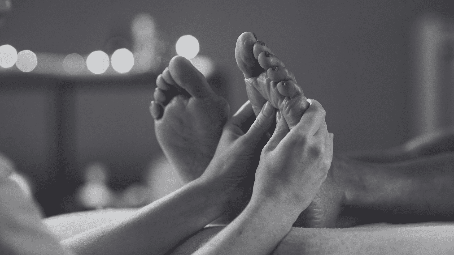 Someone receiving a relaxing foot massage, focus on hands applying pressure.